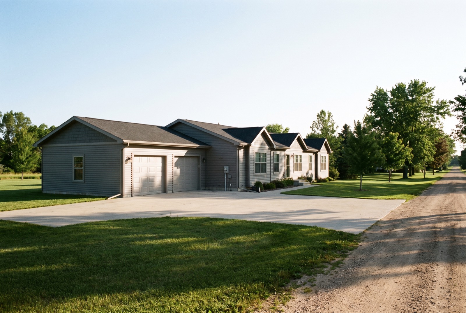 A manufactured home with an attached garage on a sunny lot